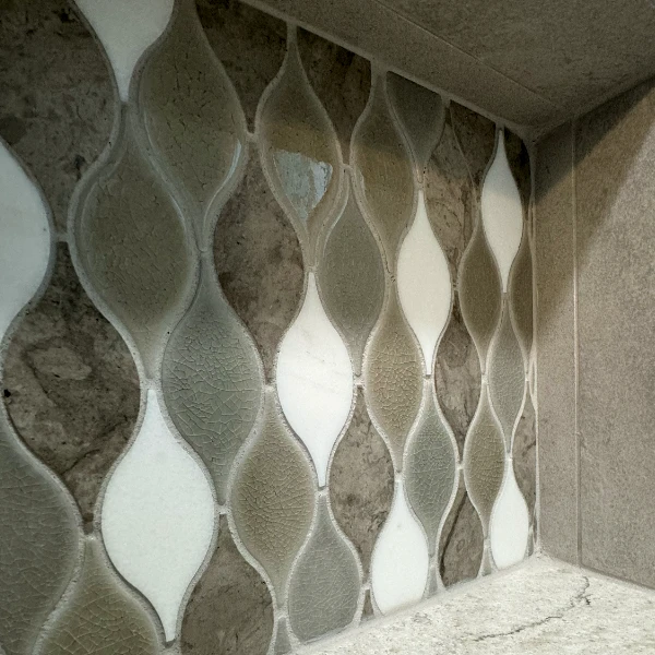 wavy tiles in a vertical pattern on the back of a shower niche