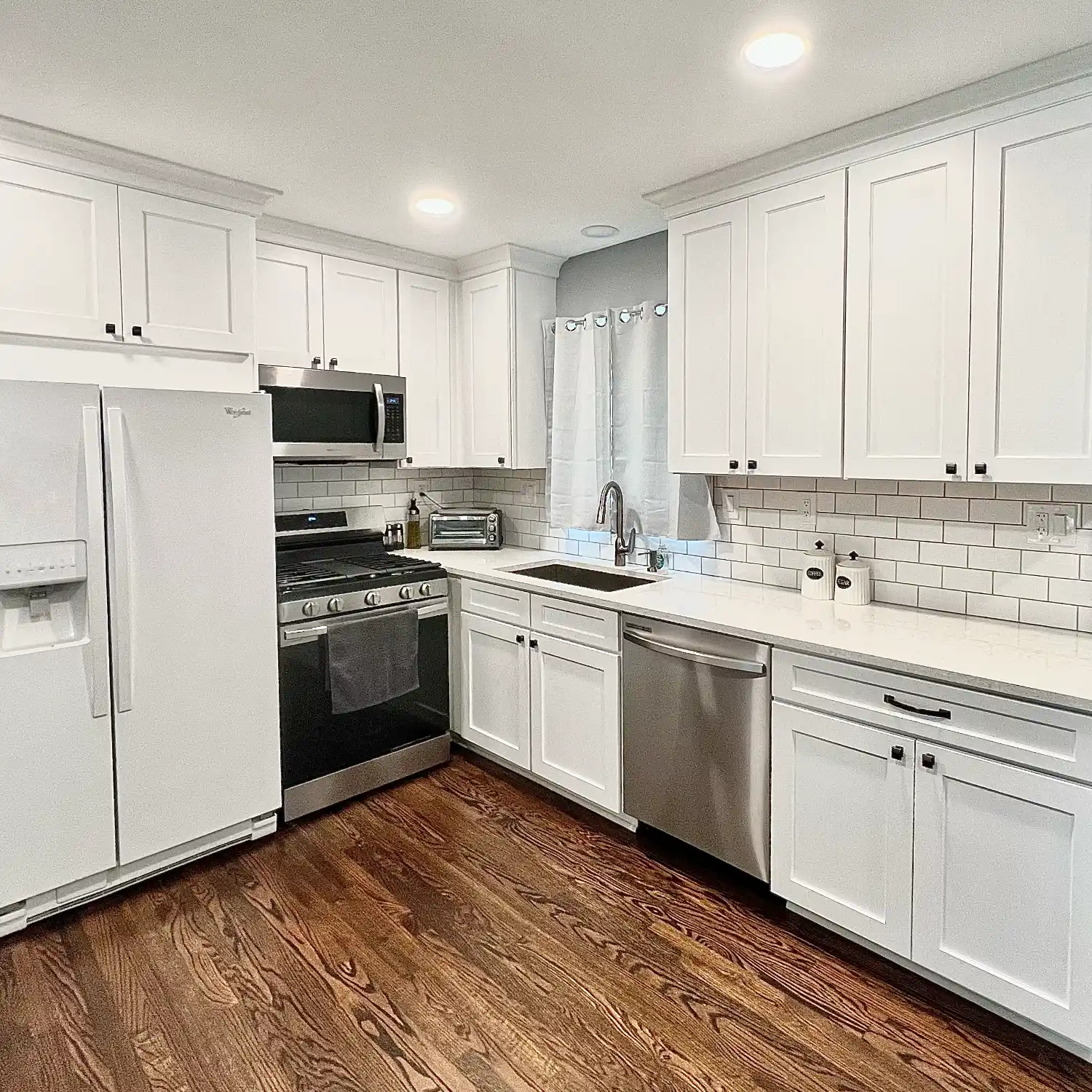white kitchen cabinets with crown molding at top and classic subway tile backsplash