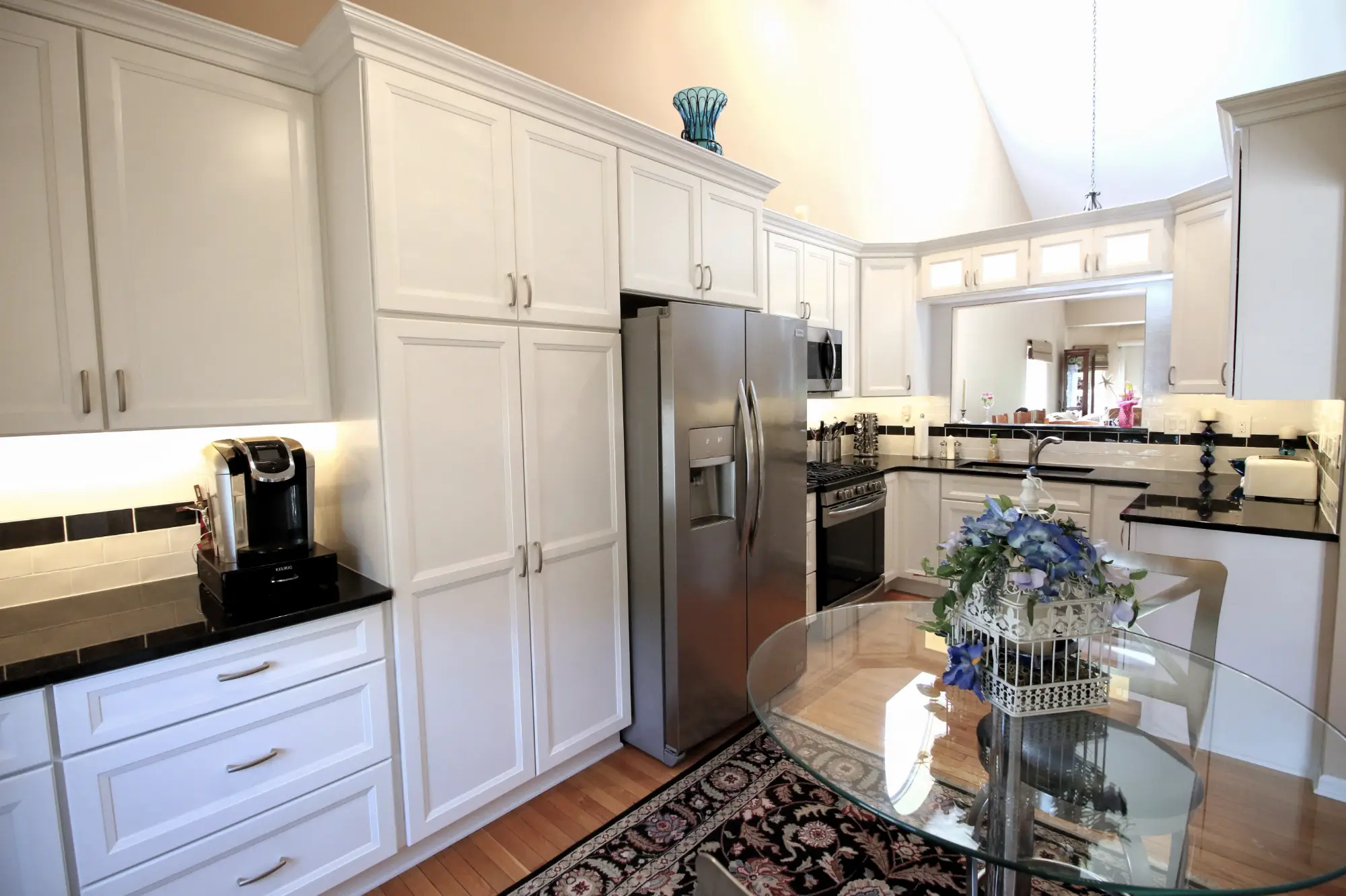 A contemporary remodeled kitchen with white cabinets.